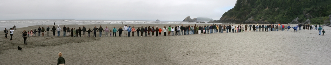 Photo: a long line of people hold hands on Moonstone Beach